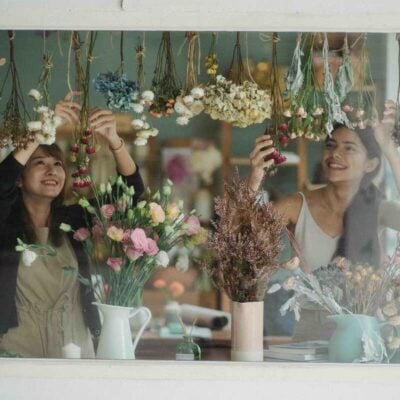 ragazze che ssitemano fiori all'interno del negozio