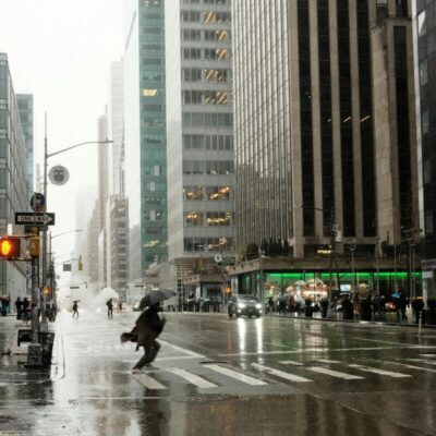 persona che attraversa la strada a New York sotto la pioggia