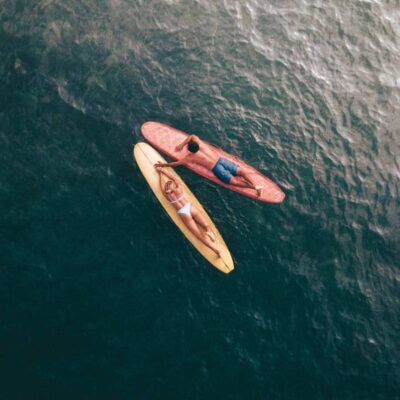 due ragazzi su tavole da surf in mezzo al mare