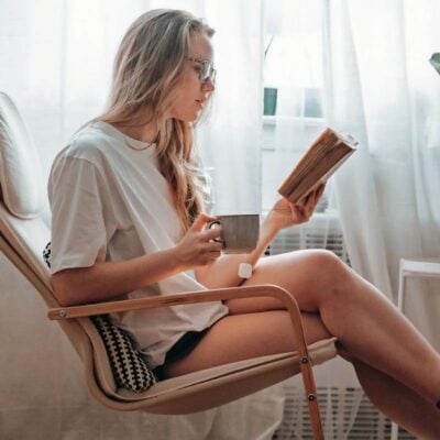 ragazza che legge libro seduta