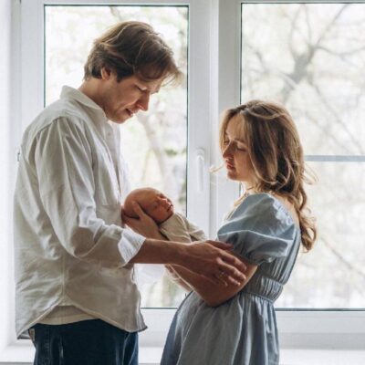 Una coppia e un bambino di fronte a una finestra